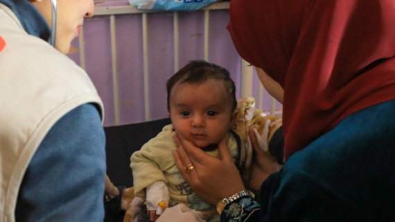 In Palestine, a medical team attends to a baby.