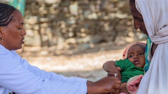 Läkare ger ett litet barn vaccin