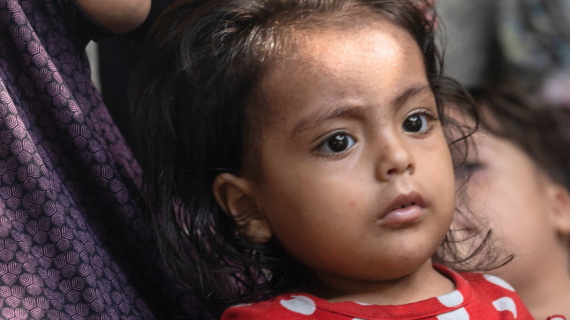 Ett barn som sitter hos en vuxen