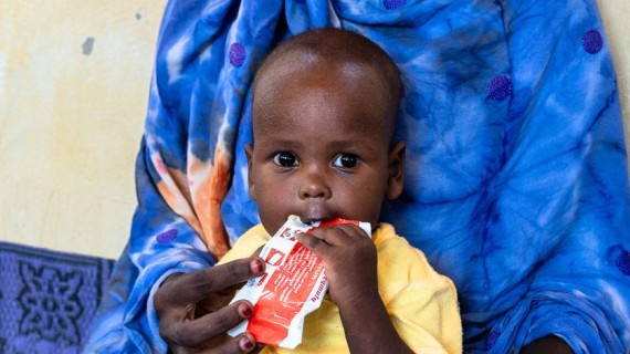 Ett barn äter en påse med nötkräm